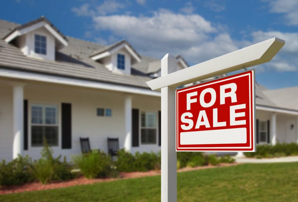 A for sale sign in front of a new home