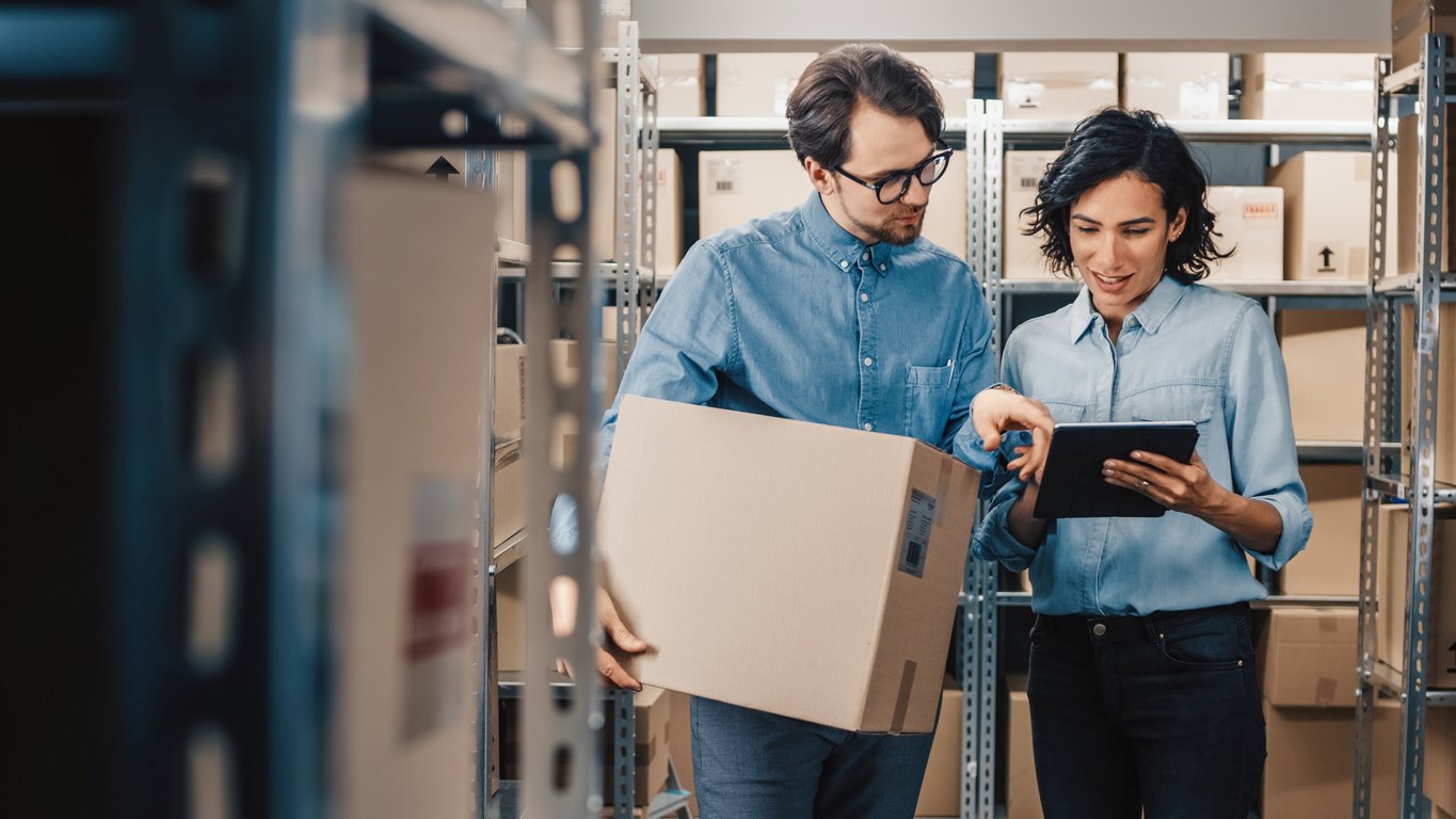 Two people organize their supplies inside a self storage unit.